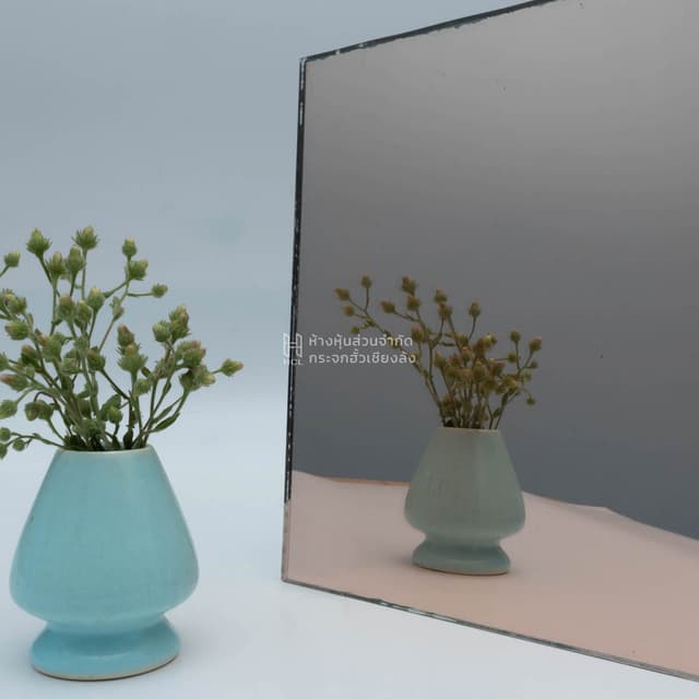 a pink mirror with reflection of flower jar